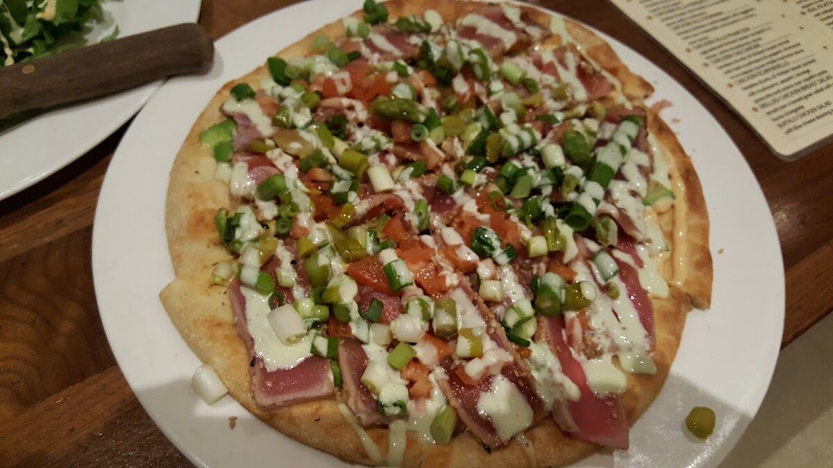 Thin-crust pizza with prosciutto and scallions